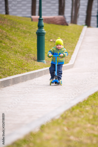 Cute little boy riding a kick scooter © len44ik