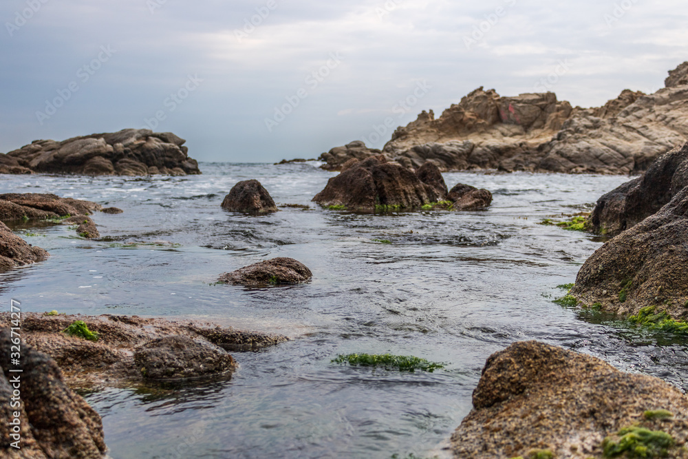 Nice landscape of rocks with calm sea and blue background in Costa Brava, Lloret de Mar