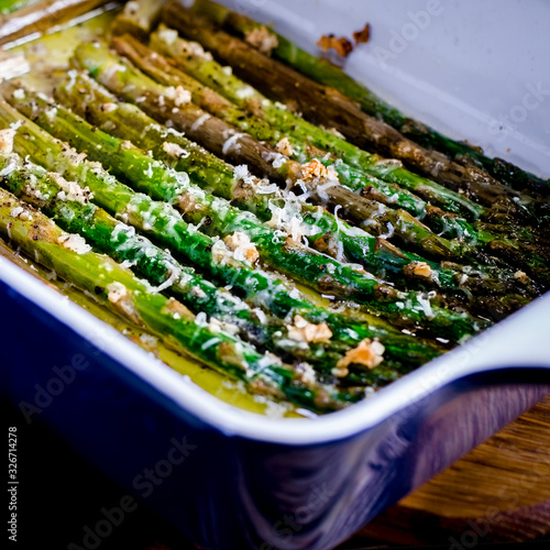 Green juicy asparagus is in ceramic form in olive oil