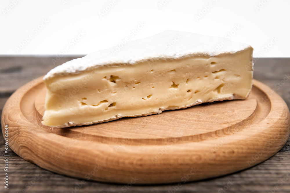 delicious brie cheese on wooden plate