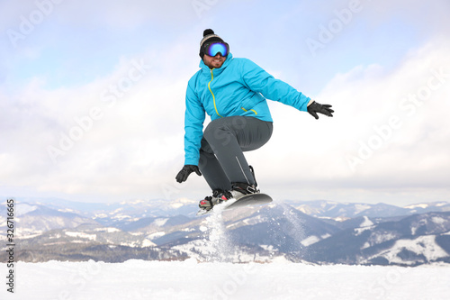 Male snowboarder on snowy hill. Winter vacation