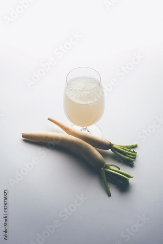 Healthy Fresh daikon juice or Mooli extract drink in a glass with raw mule