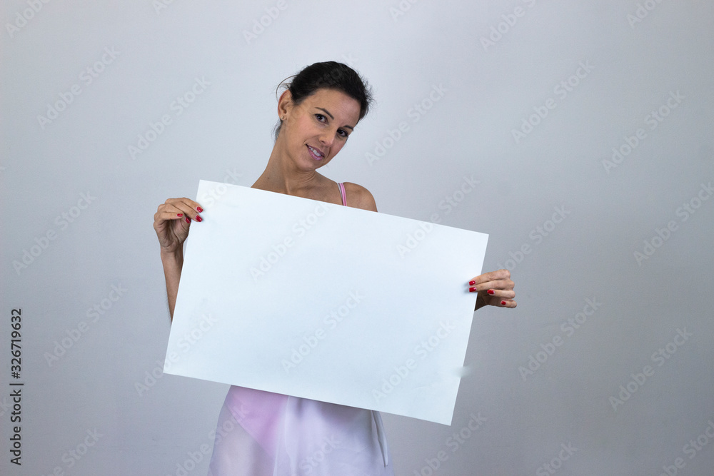 Portrait of happy pretty middle age womansalad smiling holding a big white placard, sign copy space, isolated on gray background studio shotblack sweater, denim jacket, jeans, dark air. Place for you Portrait of happy pretty middle age womansalad smiling holding a big white placard, sign copy space, isolated on gray background studio shotblack sweater, denim jacket, jeans, dark air. Place for you