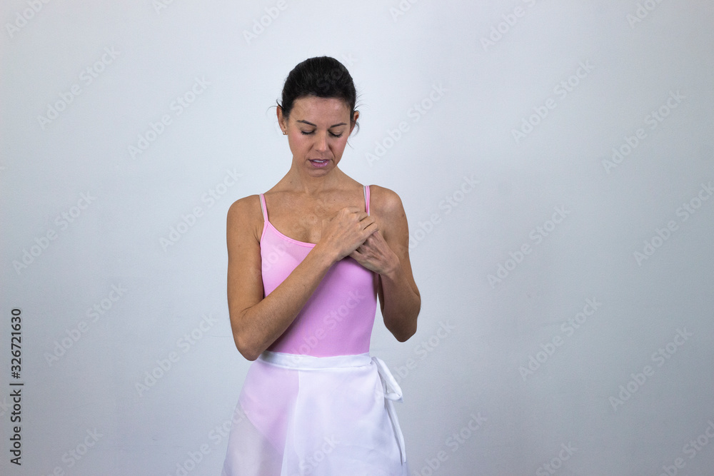 Portrait of ballet dancer, middle age woman with closed eyes, keeps hands on chest, isolated on gray background studio shot, ballet jersey, dark air. Place for your text in copy space. Portrait of ballet dancer, middle age woman with closed eyes, keeps hands on chest, isolated on gray background studio shot, ballet jersey, dark air. Place for your text in copy space.