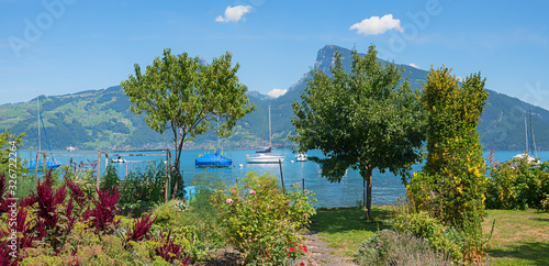 pictorial lake shore Thunersee with garden in the front and view to Niederhorn mountain, tourist resort Faulensee swiss photo