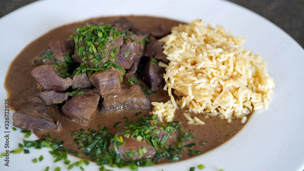 roasted liver, heart and kidneys from a red deer with sauce and rice roasted liver, heart and kidneys from a red deer with sauce and rice