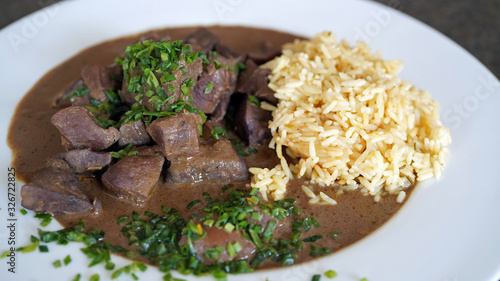 roasted liver, heart and kidneys from a red deer with sauce and rice