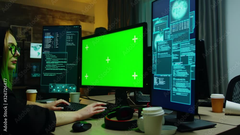 Zoom in shot of hacker girl in front of computer with green screen Zoom in shot of hacker girl in front of computer with green screen