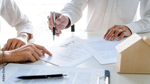 Real Estate Agent broker or House developer showing contract for buying house agreement to consultant employee.