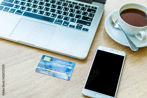 Credit card of laptop computer,smartphone and coffee cup on wooden background, Online banking Concept