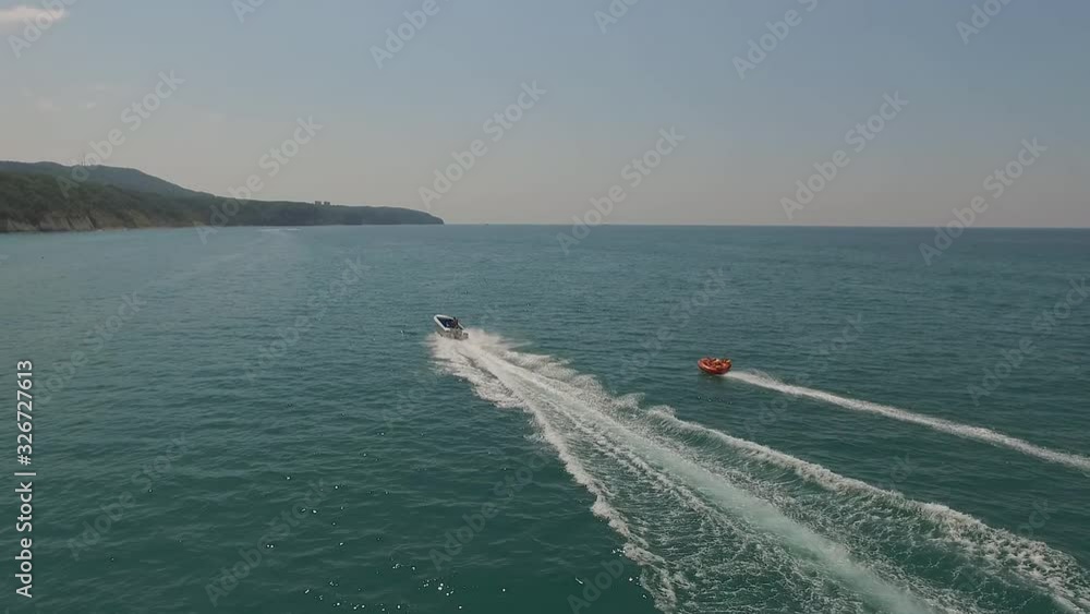 Tubing on the sea. The boat drags extreme athletes. Cool dynamic