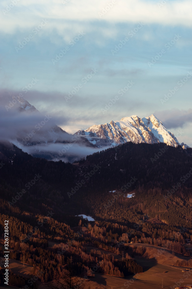 alps in winter at a  cold day with low clouds and nice view