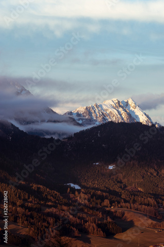 alps in winter at a cold day with low clouds and nice view