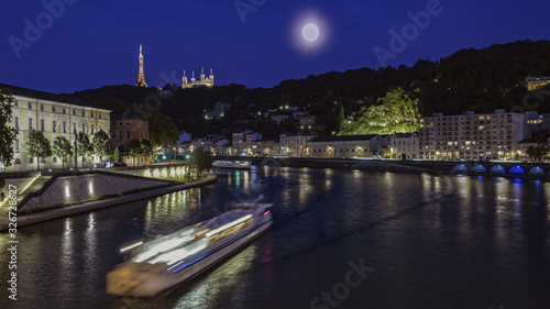 Schilderij op canvas Ballade en vélo, à Lyon, de jour comme de nuit, passage d'une péniche, de nuit, sous un pont de la rivière Saône