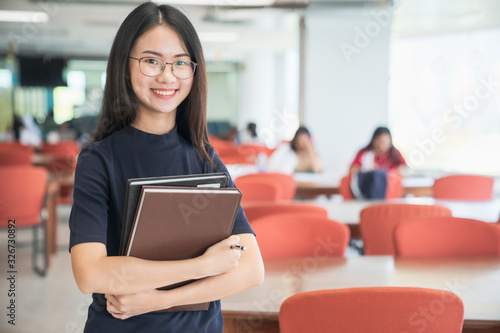 Back to school education knowledge college university concept  Beautiful female college student holding her books smiling happily standing in library  Learning and education concept