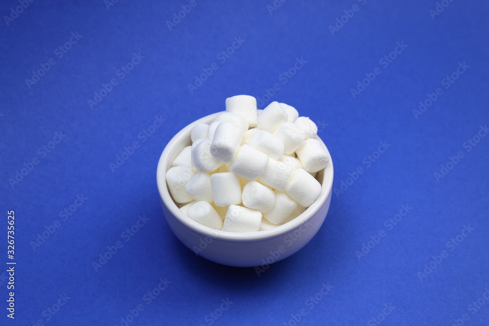 White little marshmallows lies in a white plate White little marshmallows lies in a white plate