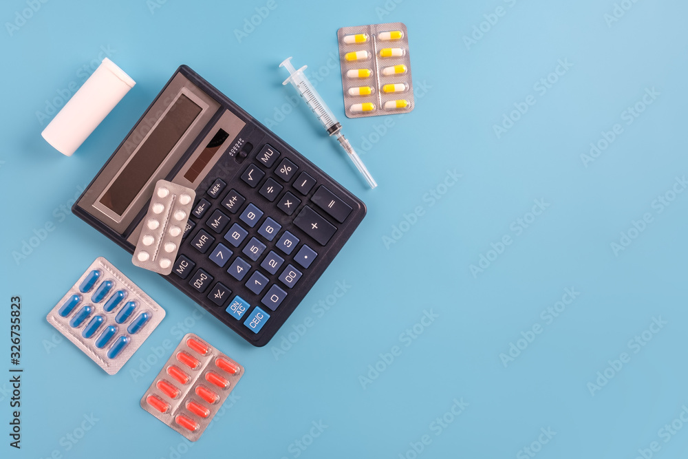 Calculator, syringe, thermometer, pills and sthetoscope on blue background. Calculator, syringe, thermometer, pills and sthetoscope on blue background.