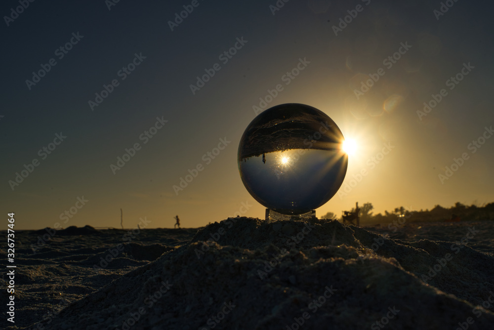 Nahaufnahme einer Glaskugel mit Sonnenuntergang am Strand auf Sanibel Island