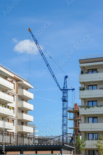 Construction crane between apartment buildings on a sunny summer day