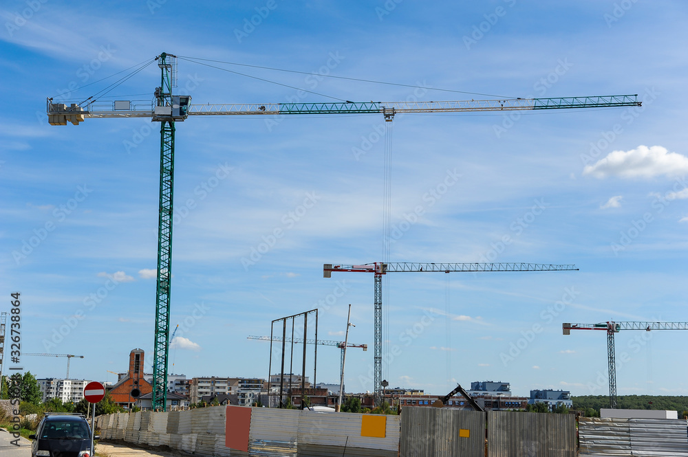 Many construction cranes on residential area