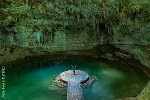 Woman enjoying the view of Suytun Cenote from the top Yucatan Mexico North America photo