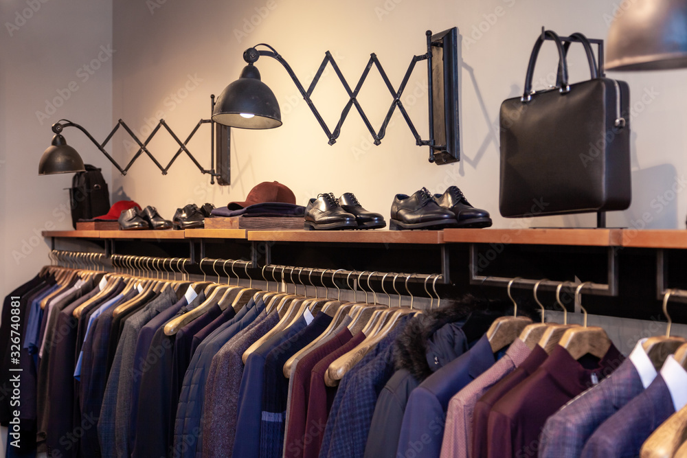 Closeup colorful male female clothes shoes in boutique hanging on hangers clothing rack. Concept opening luxury shop shopping mall store sale retail fashion store second hand outlet. Stock Adobe Stock