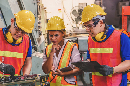 Engineer with Female mechanical worker with yellow safety helmet checking on production in a factory. Industrial, Mechanic, Engineering Concept. 