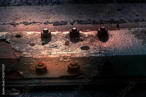 Sunrise shows rust damage to bolts and iron on bridge photo