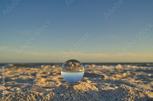 Nahaufnahme einer Glaskugel am Strand auf Sanibel Island mit Meer und Horizont im Hintergrund photo