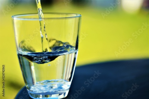 Wallpaper Mural Water poured into transparent glass, green background, writing space, healthy lifestyle, wave, laminar liquid, drop Torontodigital.ca