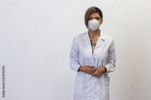 Portrait of serious  young woman with a protective face mask. Coronavirus. Doctor, nurse, pharmacist, beauty therapist, scientist, ophthalmologist, optometrist, beautician, healthcare, isolated on whi