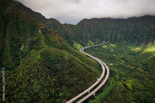 Hawaiian Highway above the lush green forests  snaking through the mountains on a cloudy day.  Impressive road and architecture