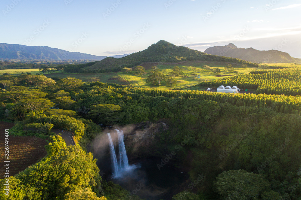 Hawaiian waterfall in front of Mountains, sunny morning beautiful lush greenery