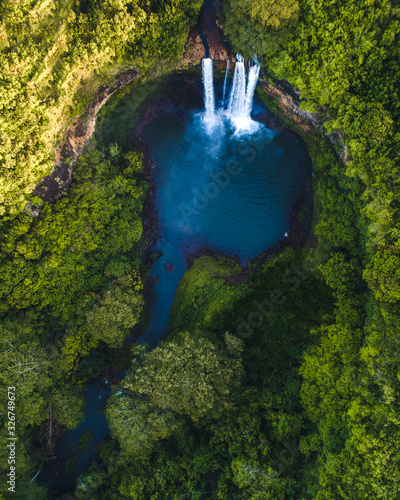 Tableau sur toile Magical Hawaiian waterfall surrounded by trees at sunrise, beautiful golden ligh