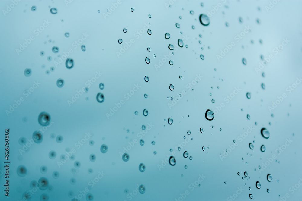 Isolated raindrops close up with a blue background