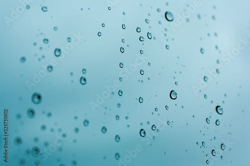 Isolated raindrops close up with a blue background