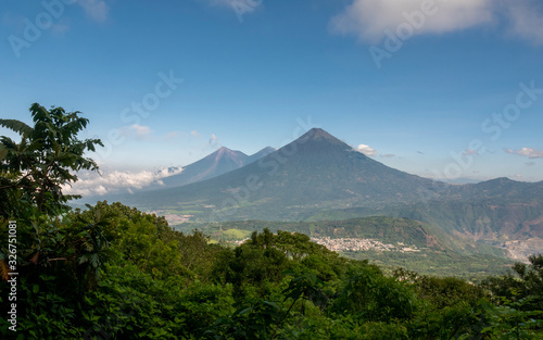 Acatenango and Fuego Volcanoes in Guatemala seen from behind vegetation