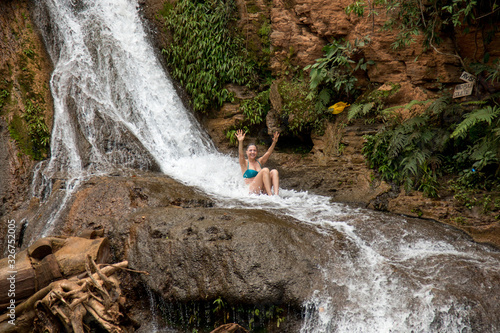 Woman Enjoying herself at the Waterfall known as Cachoeira Paraiso do Cerrado located near the city of Mambia and Damianopolis in the State of Goias, Brazil. photo