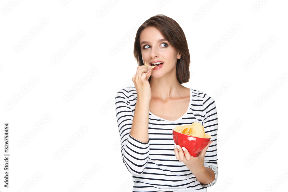 Beautiful young woman eating and holding potato chips in bowl on white background Beautiful young woman eating and holding potato chips in bowl on white background