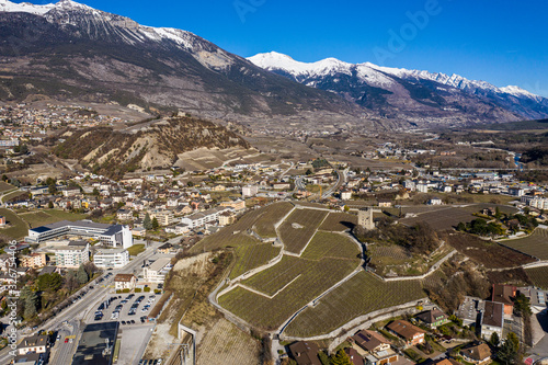 Wall Mural Aerial view of the city of Sierre in Canton Valais with vineyars, and a castle a
