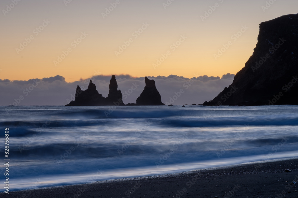 Dark silhouettes of tall cliffs in the sea near Vik, Iceland