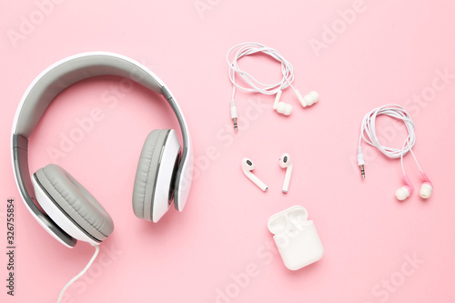 Three different earphones on pink background
