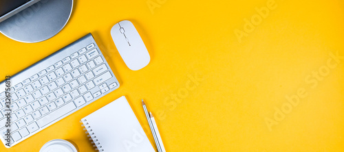White keyboard, mouse and Notepad on yellow background. Flat lay and top view, copy space for text photo