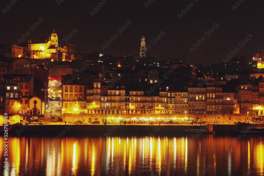 Barrio de la Ribeira de Oporto iluminado en la noche y su reflejo en el río Duero. Fotografía desde Vila Nova de Gaia (Portugal).