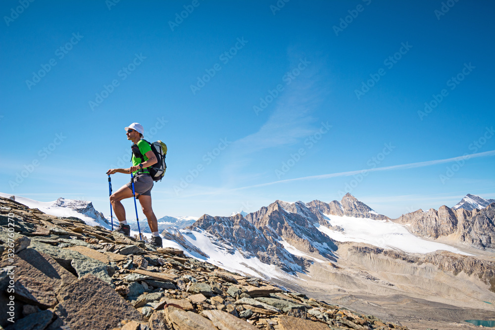 Man trekking in the Alps in a beautiful sunny day. Grand Paradiso National Park. Italy