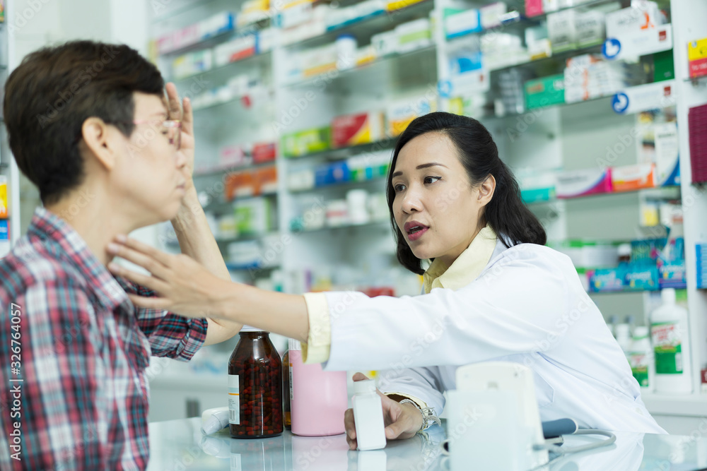 Asian woman pharmacist chemist talking or advice to customer, Retirement age female, patient on pharmacy drugstore. people, health care and treatment of primary illnesses concept, Elderly Disease