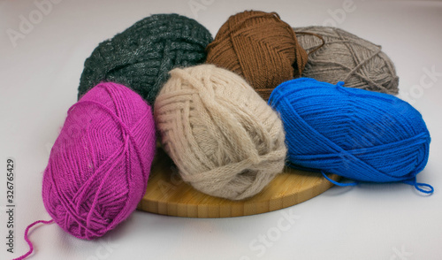 wool of different colors on the wooden board on the white table