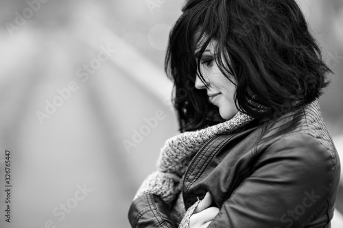 Side view of a young beautiful woman standing on the bridge and enjoing her life, urban lifestyle. .Soft focus, black and white photo.
