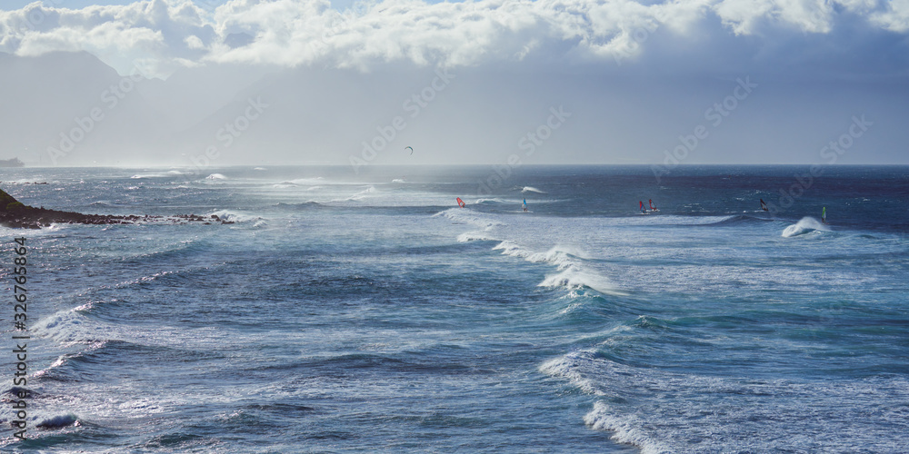 Panoramic view of the ocean with windsurfers on a windy day on Maui island in Hawaii.