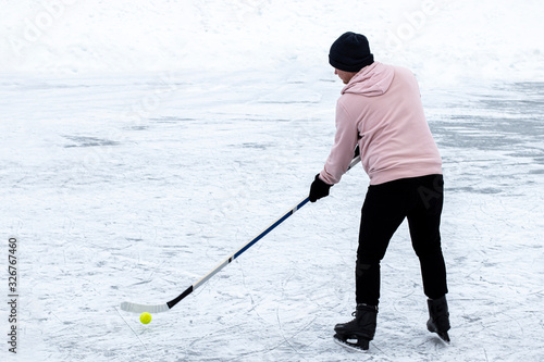 A young guy playing amateur ball hockey on ice